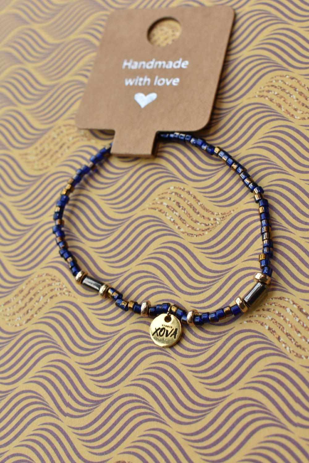 Handgemaakte armband donkerblauw met goudkleurige bedel | Studio XOVA No.59