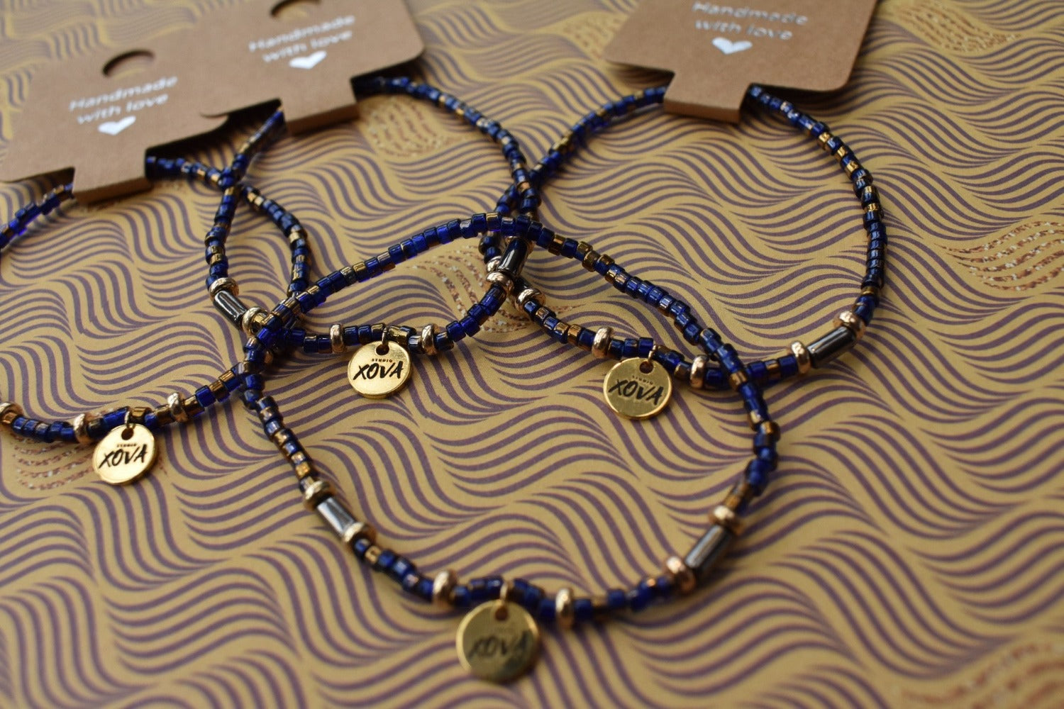 Handgemaakte armband donkerblauw met goudkleurige bedel | Studio XOVA No.59