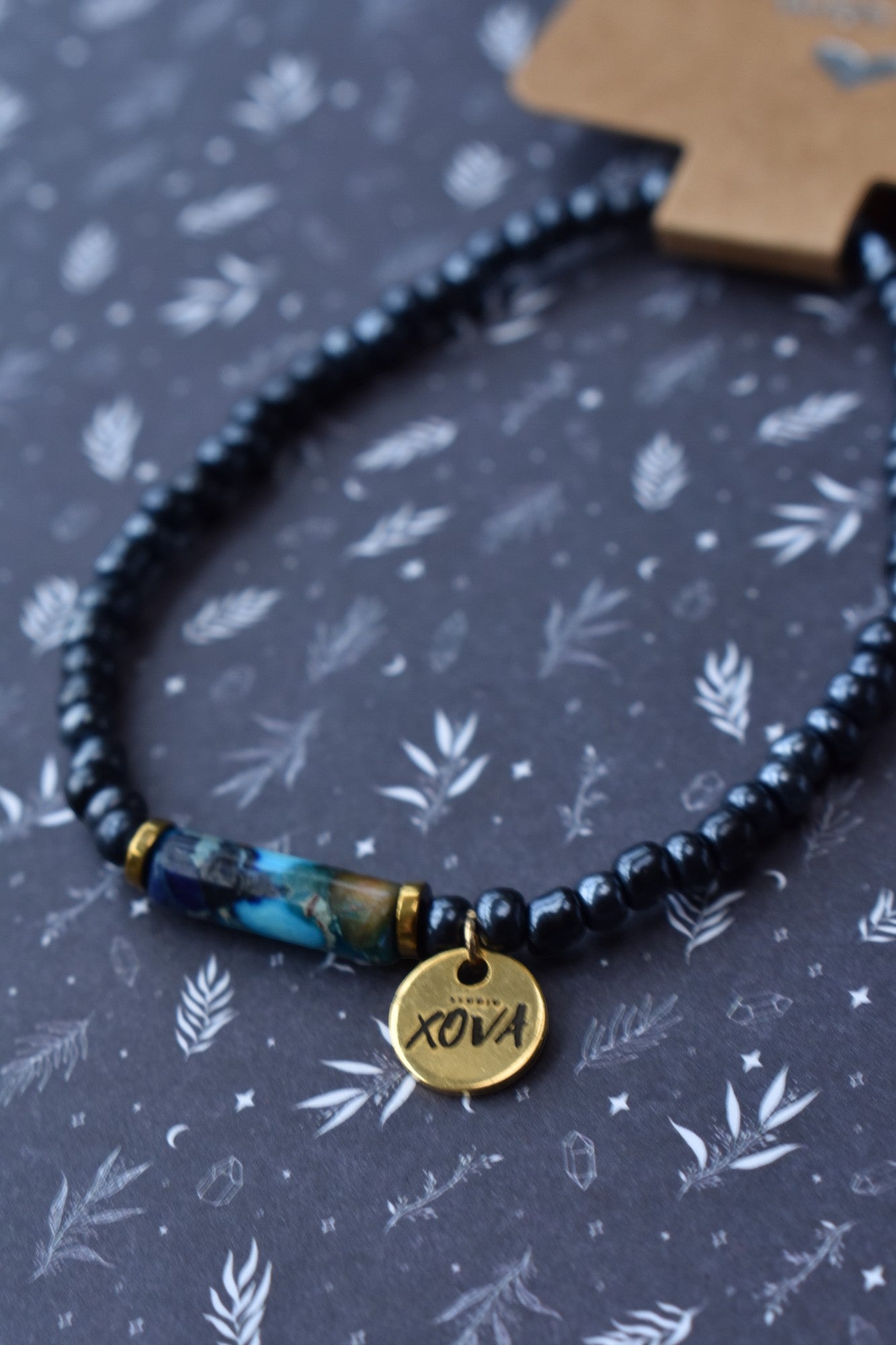 Handgemaakte (en op maat gemaakte) armband met donkerblauwe kralen, uniek element van polymeer klei en goudkleurige bedel | Studio XOVA No.49